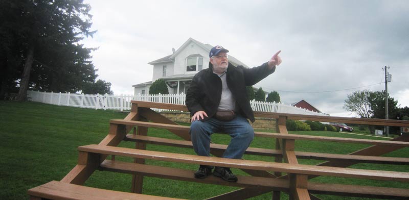 Ultimate Strat Baseball - Photo of the bleachers on the 1st base side of the Baseball Field with Wolfman Shapiro on the Fields of Dreams Movie Site, July 2016
